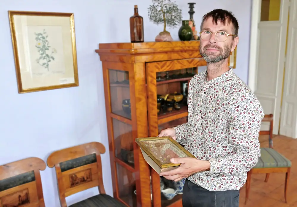 Der Leipziger Kunsthändler Martin Koenitz hält eine Biedermeier-Antiquität in seinen Händen.